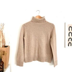 Beige colored turtleneck, sweater with button detail